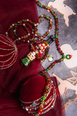 Christmas themed handmade pendant bracelets and necklaces on festive background surrounded by Christmas balls and nutcracker.