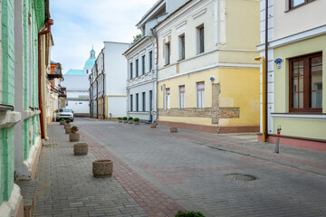 Fototapeta premium Quiet old European street with historic buildings and car parked near the sidewalk