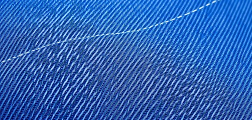 Close-up texture of worn indigo denim fabric, showing distinct stitching and fading,  fabric,  threads