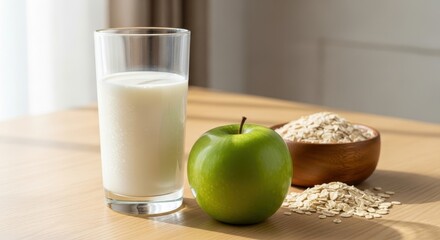 Green apple and glass of milk beside oats on wooden surface