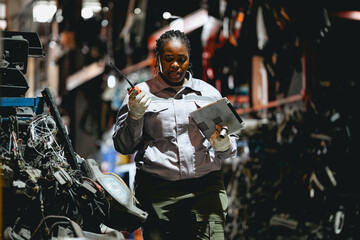 Female technician check used car damaged engine block at scrapyard warehouse recycle area part....