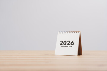 Desk calendar the year 2026 with the text Happy New Year on table in office background. Celebration and new beginnings. Resolution and Goals Plan Action Concept. Schedule in 2026