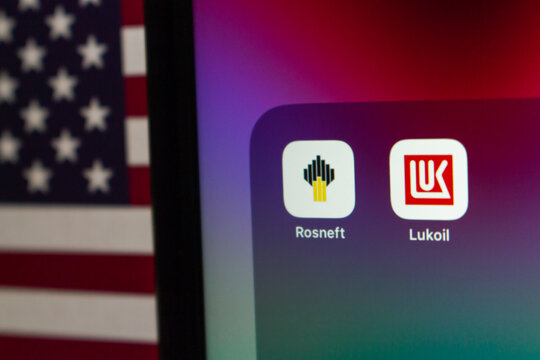 Quito, ECUADOR - Oct 27 2025 : Rosneft and Lukoil icons displayed on a screen with the U.S. flag in the background.