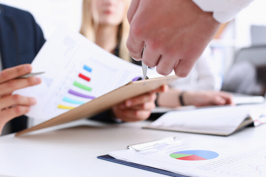 Group of people deliberate on problem with clipboard pad closeup. White collar check money papers, stock exchange market, earnings list, partnership agreement discussion concept
 - Powered by Adobe