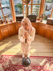 A young woman sings into a mic at a cozy cafe with wooden decor and natural light