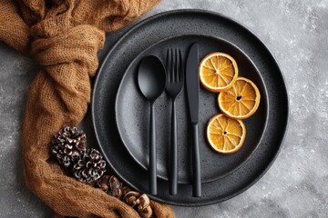 Overhead shot of a plate with dried orange slices and black cutlery set