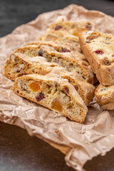 Italian Almond Biscotti biscuits in a rustic home made pottery bowl. Studded with almonds and cranberries, these twice-baked treats are aromatic and inviting. Ideal.