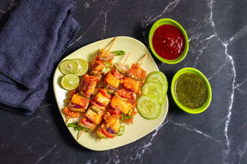 Paneer satay is a grilled Indian appetizer made with marinated paneer cubes, skewered, and served with spicy peanut or yogurt dip.
