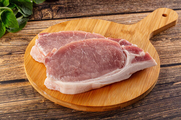 Raw pork steak over board