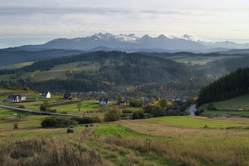 Beautiful scenery of snow-covered Tatras Mountains and village Sromowce Wyzne in autumn scenery in evening light, Poland