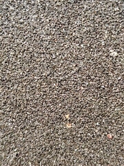 Coarse dark asphalt texture close-up.