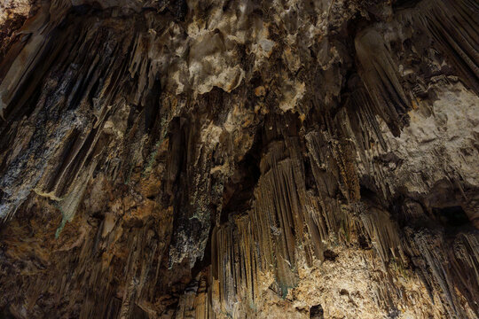 Karst Cave Ceiling with Vertical Stalactite Curtains and Rich Mineral Detail