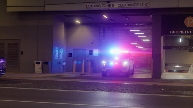 Close-up shot of a police car with flashing red and blue lights parked on a Miami street at night. Emergency vehicle symbolizing law enforcement and public safety	
