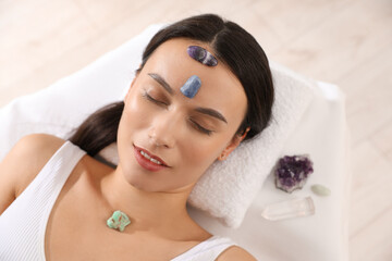 Woman undergoing crystal therapy to heal or restore her aura indoors, top view