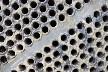 Tube sheet plate of heat exchanger or boiler closeup texture macro diagonal background full of...