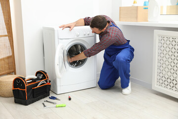 Obraz premium Professional repairman fixing broken washing machine indoors