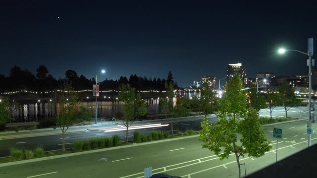 Evening time lapse views from Harrison Street show Lake Merritt&rsquo;s surface shimmering while the city skyline gradually illuminates, blending motion and calm across downtown Oakland.