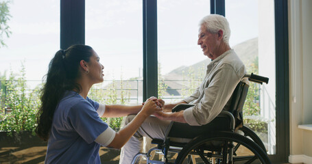 Holding hands, caregiver and senior man with wheelchair, support and counseling in nursing home....