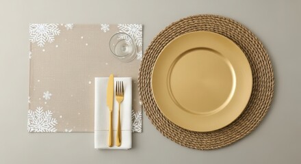 A gold charger plate on a woven placemat with a snowflake napkin and cutlery