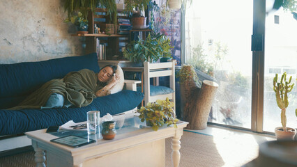 Sick, fatigue and woman with sleeping on sofa for flu burnout, viral infection or disease recovery. Respiratory illness, tired person or rest with blanket in home for healing, low energy or exhausted