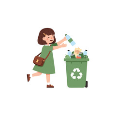 A young girl in a green dress throws a plastic bottle into a green recycling bin filled with various recyclable materials.