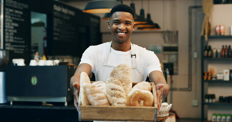 Black man, portrait and small business with bread in bakery for food, breakfast or wheat. Male person, pastry chef or baker with smile or basket of loafs or rolls in cafe for hospitality service
