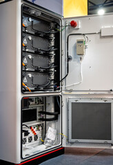 Inside view of a sophisticated industrial energy storage system cabinet, revealing stacked battery...
