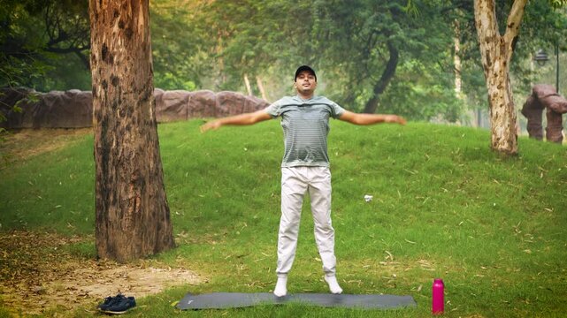 A man doing jumping jacks &mdash; a full-body exercise that works the muscles in the arms, legs, and core. This exercise helps strengthen muscles, improve coordination, and boost overall fitness.