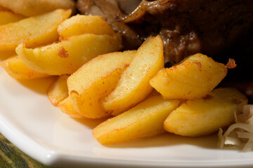 baked potato wedges close together, prepared to accompany meat