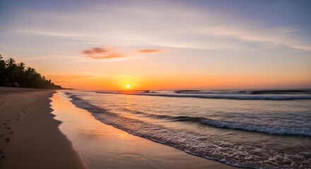 Obraz premium A breathtaking sunset paints the sky with warm hues over a serene beach, with gentle waves reflecting the fading light