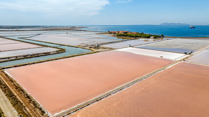Aerial view of the Trapani salt pans, Sicily, Italy. Wide view of salt evaporation ponds. The Favignana Island is in the background, at horizon.