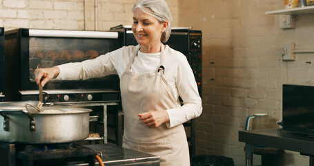 Baker, woman and frying donuts in kitchen for lunch order, baking process and catering service. Small business, mature person and happy with dessert preparation in restaurant for gastronomy and snack
