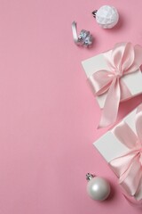 Festive gift boxes tied with pink ribbons on a color background, Christmas and New Year holiday
