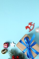 Christmas vertical holiday gift decorations, pine branches, berries on blue background. Top view