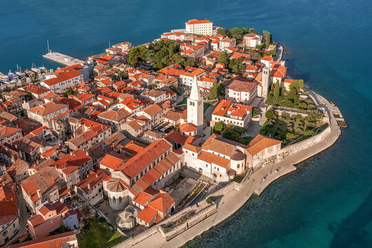 Aerial view of terracotta roofs meet the azure Adriatic, framing the iconic Euphrasian Basilica and harbor, Pore&Auml;, Istria County, Croatia.
