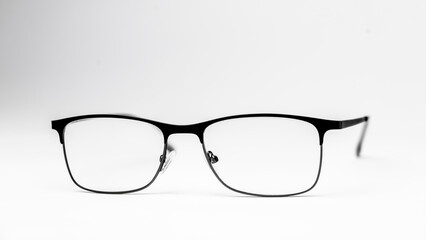 A pair of black glasses with a white frame. The glasses are sitting on a white background. The glasses are black and white, and they have a rectangular shape