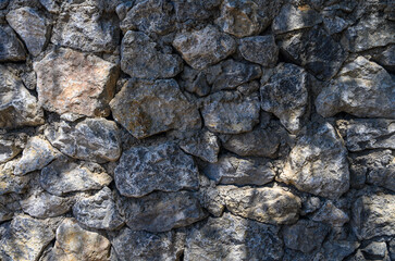 Sunlit natural stone wall background