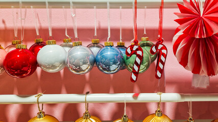 Colorful Christmas decorations including red, white, and blue ornaments, candy canes, and a red paper fan. Perfect for festive holiday settings.