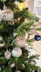 A decorated Christmas tree with various ornaments. The tree features green branches adorned with blue and silver baubles, creating a festive atmosphere.