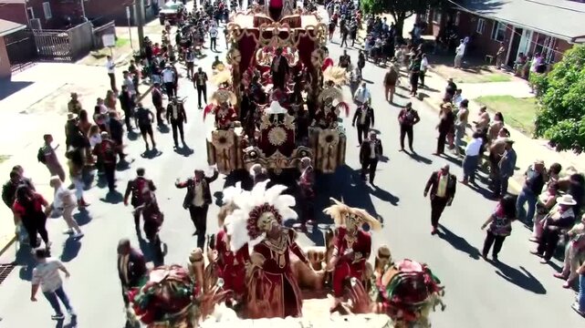 cultural parade with numerous people and a decorated float.