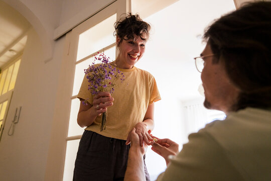 Happy woman getting engaged with man at home