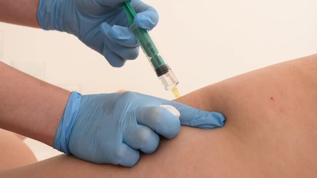 Injections of lipolytic into hips for weight loss and muscle definition close-up. doctor in sterile gloves inject lipolytic into hips, butt subcutaneously	