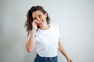Smiling businesswoman in casual white t shirt posing on white background