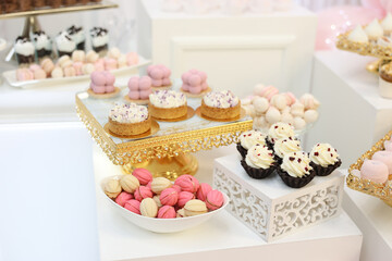Elegant dessert table with assorted pastel cakes, cupcakes, and candies. Perfect for weddings, baby showers, or birthdays. Gold trays and pink balloons create a luxury celebration mood. 
