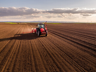 Obraz premium Farming tractor sowing seeds in fertile field