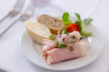 Ham rolls with microgreens, bread, and cherry tomato