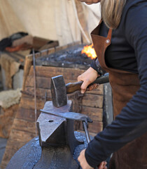 mujer herrera forjadora en el yunque trabajando con el martillo manos forja fuego 4M0A8408-as25