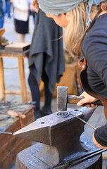 mujer herrera forjadora en el yunque trabajando con el martillo manos forja fuego 4M0A8421-as25
