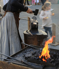 mujer herrera forjadora en el yunque trabajando con el martillo manos forja fuego 4M0A8439-as25