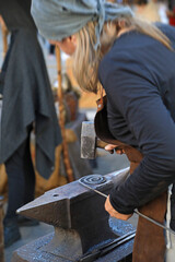 mujer herrera forjadora en el yunque trabajando con el martillo manos forja fuego 4M0A8492-as25